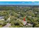 Scenic aerial view showcases the home nestled among lush trees, with a glimpse of the water in the distance at 104 Cypress Pond Rd, Palm Harbor, FL 34683