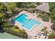 Aerial view showcasing the community pool surrounded by lounge chairs, greenery, and a building at 104 Cypress Pond Rd, Palm Harbor, FL 34683