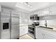 Updated kitchen featuring stainless steel appliances, granite countertops, and white cabinetry at 104 Cypress Pond Rd, Palm Harbor, FL 34683
