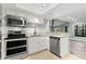 Open kitchen layout with stainless appliances, granite counters, and bright lighting at 104 Cypress Pond Rd, Palm Harbor, FL 34683