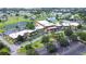 An aerial view shows a neighborhood clubhouse, surrounded by a large parking lot, lush greenery, and a serene lake with a fountain at 2104 Hembury Pl # 33, Sun City Center, FL 33573