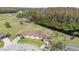 An aerial view of a home nestled on the edge of a serene pond and a lush forest, featuring a well-maintained lawn and lovely shrubbery at 2104 Hembury Pl # 33, Sun City Center, FL 33573