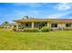 Spacious backyard featuring lush green lawn, covered patio, and views of mature landscaping at 2104 Hembury Pl # 33, Sun City Center, FL 33573