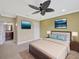 This bedroom is spacious, carpeted, and includes views of the attached bathroom at 2104 Hembury Pl # 33, Sun City Center, FL 33573