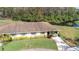 An exterior view of a well-maintained single-story home, featuring a well-manicured lawn and colorful shrubbery and a brick driveway at 2104 Hembury Pl # 33, Sun City Center, FL 33573
