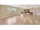 Spacious living room featuring new light wood flooring and view into the kitchen and enclosed porch at 2104 Hembury Pl # 33, Sun City Center, FL 33573