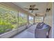 Relaxing screened porch with ceiling fans and wicker furniture, overlooking lush greenery and a canal at 2104 Hembury Pl # 33, Sun City Center, FL 33573