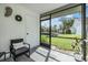 Relaxing screened porch overlooking a lush green yard and parking area at 3551 Magnolia Ridge Cir # 702, Palm Harbor, FL 34684