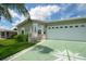 Tan single-story home with a two-car garage and landscaped lawn at 37449 Gill Ave, Zephyrhills, FL 33541