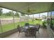 Relaxing screened porch with seating for four and ceiling fan at 37449 Gill Ave, Zephyrhills, FL 33541