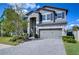 Two-story house with gray siding, stone accents, and a paved driveway at 10330 Stallion Fields Way, Tampa, FL 33647