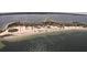 Sweeping aerial view of a sandy beach with palm trees and a connecting road, surrounded by sparkling turquoise waters at 2571 Cyprus Dr # 1-202, Palm Harbor, FL 34684