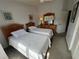 Well-lit bedroom with twin beds, dresser, and closet, perfect for guests or children, offering a cozy atmosphere at 2571 Cyprus Dr # 1-202, Palm Harbor, FL 34684