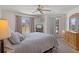 Cozy bedroom with soft lighting, a ceiling fan, balcony access, and neutral tones providing a relaxing and comfortable retreat at 2571 Cyprus Dr # 1-202, Palm Harbor, FL 34684