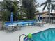 Community pool area with tables, umbrellas, and lounge chairs at 2571 Cyprus Dr # 1-202, Palm Harbor, FL 34684