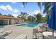 Relaxing community pool area with tables, chairs, and sunny skies at 2571 Cyprus Dr # 1-202, Palm Harbor, FL 34684