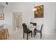 Charming dining area featuring a glass-top table, four chairs, white tile floors, and a decorative floral arrangement at 2571 Cyprus Dr # 1-202, Palm Harbor, FL 34684