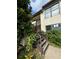 Close up exterior of the home with a wooden staircase, stucco exterior, and vibrant plants at 2571 Cyprus Dr # 1-202, Palm Harbor, FL 34684