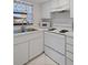Bright kitchen featuring white appliances, ample cabinet space, and a clean, modern design creating a functional cooking area at 2571 Cyprus Dr # 1-202, Palm Harbor, FL 34684