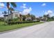Inviting neighborhood street lined with tropical palm trees and vibrant landscaping at 2571 Cyprus Dr # 1-202, Palm Harbor, FL 34684