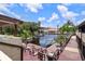 Deck with table and chairs with a beautiful water view of docked boats, a lake, and a clear blue sky at 2571 Cyprus Dr # 1-202, Palm Harbor, FL 34684