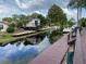 Waterfront view featuring docks, canal, and exterior of a small house under a cloudy sky at 2571 Cyprus Dr # 1-202, Palm Harbor, FL 34684