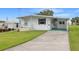 White single wide mobile home with carport and green driveway at 6054 Crestview Ln, Zephyrhills, FL 33542