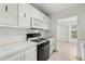 Kitchen with white cabinets and black appliances at 9950 62Nd N Ter # 106, St Petersburg, FL 33708