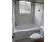 Clean bathroom with a white tub, toilet, and tiled walls at 18001 Richmond Place Dr # 425, Tampa, FL 33647