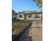 Single-story home with a neatly kept lawn and a brick walkway leading to the covered front porch at 3718 E Henry Ave, Tampa, FL 33610