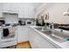 White kitchen with stainless steel sink and appliances at 4234 Chesterfield Cir, Palm Harbor, FL 34683