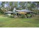 Lush yard and home exterior view featuring shady patio, seating and grill at 5143 Culbreath Rd, Brooksville, FL 34601