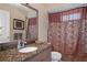 Bathroom with granite countertop, ornate mirror, and shower-tub combination with a patterned curtain at 5143 Culbreath Rd, Brooksville, FL 34601