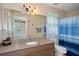 Bathroom with a large mirror, granite countertop, and a shower-tub combination with a curtain at 5143 Culbreath Rd, Brooksville, FL 34601