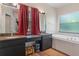 Bathroom with a double sink vanity, granite counters, and a separate soaking tub at 5143 Culbreath Rd, Brooksville, FL 34601