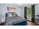 Comfortable bedroom featuring a large window providing natural light and a stylish patterned comforter at 5143 Culbreath Rd, Brooksville, FL 34601