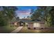 Charming single-story home with brick accents, covered porch and mature trees in a peaceful wooded setting at 5143 Culbreath Rd, Brooksville, FL 34601