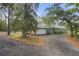 Home exterior with long paved driveway and garage, surrounded by lush trees and landscaping at 5143 Culbreath Rd, Brooksville, FL 34601