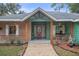 Inviting front entryway with brick and siding accents, decorative plants, and decorative doorway at 5143 Culbreath Rd, Brooksville, FL 34601