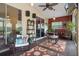 Enclosed patio space with ceiling fan, outdoor seating, TV, plants and patterned rugs at 5143 Culbreath Rd, Brooksville, FL 34601