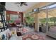 Enclosed patio space featuring ceiling fan, outdoor seating, TV and patterned rugs at 5143 Culbreath Rd, Brooksville, FL 34601