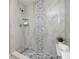 Elegant bathroom with marble-like tiles, glass shelves, and a decorative mosaic tile shower accent at 5721 12Th S Ave, Gulfport, FL 33707