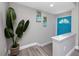Bright entryway featuring a vibrant blue front door, wood-look flooring, and stylish tropical-themed artwork at 5721 12Th S Ave, Gulfport, FL 33707