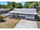 Aerial view of a gray single-story home showcasing the front yard and proximity to a screened pool enclosure at 5721 12Th S Ave, Gulfport, FL 33707