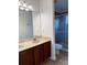 Bathroom featuring a double sink vanity, large mirror, and a tiled shower with glass door at 8550 Trail Wind Dr, Tampa, FL 33647