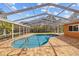 Screened pool with a safety rail and large paved deck at 9605 Woodbay Dr, Tampa, FL 33626