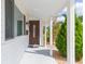 Covered front porch with a brown door and white columns at 907 La Jolla Ave, Sun City Center, FL 33573