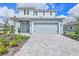 Charming two-story home showcasing a light blue facade, a paved driveway and a two car garage at 15876 Mulrion Blvd, Punta Gorda, FL 33982