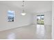 Bright living room featuring white walls, tile floors, a modern light fixture and natural light at 15876 Mulrion Blvd, Punta Gorda, FL 33982