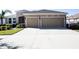 Tan two-story house with two car garage and lush landscaping at 2117 Valterra Vista Way, Valrico, FL 33594